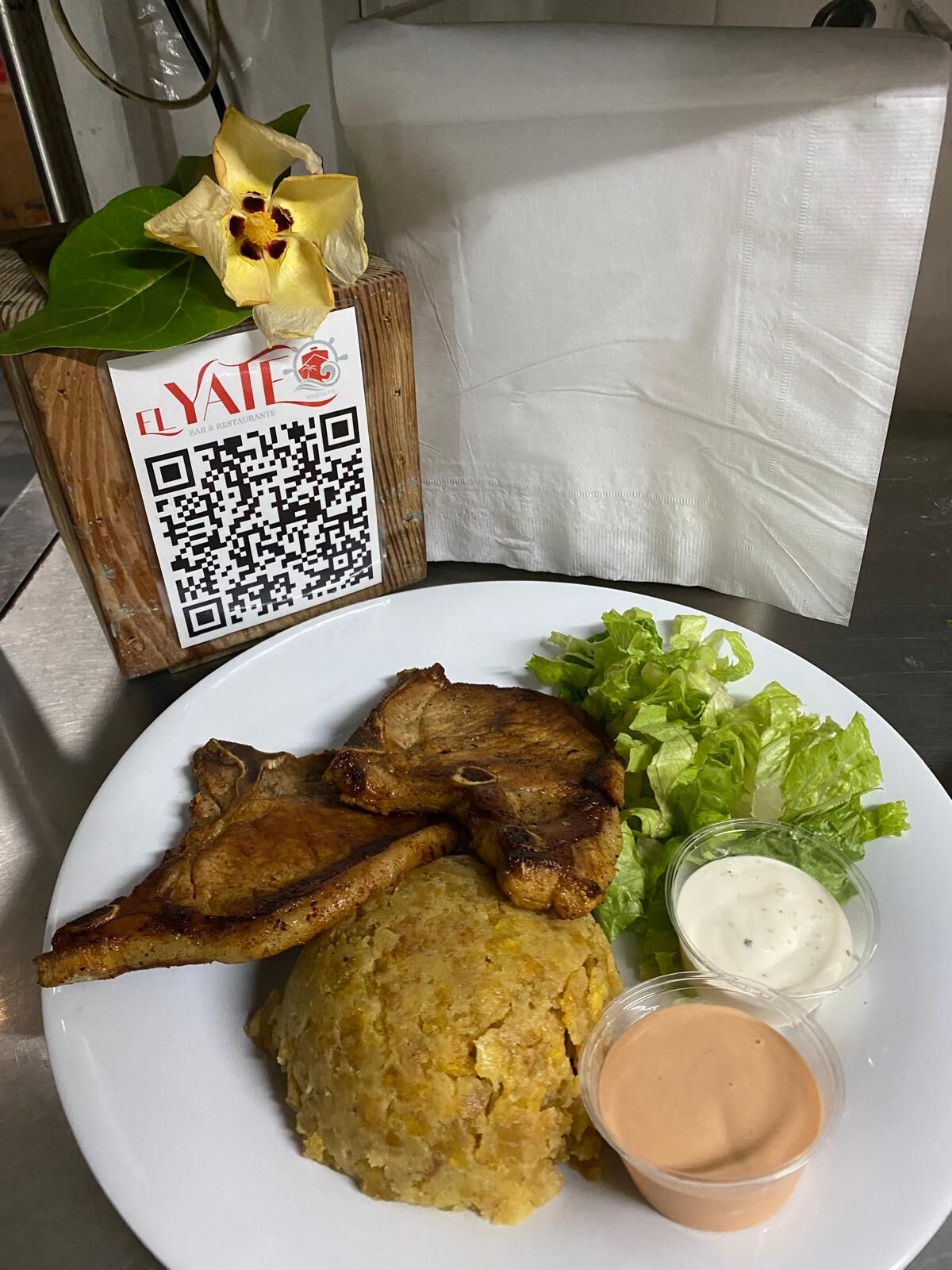 Authentic El Yate mofongo plate with grilled pork chop and dipping sauces